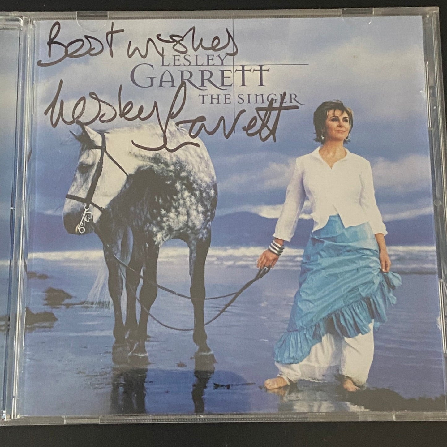 CD cover with a woman walking a horse on a beach, featuring Lesley Garrett's signature.